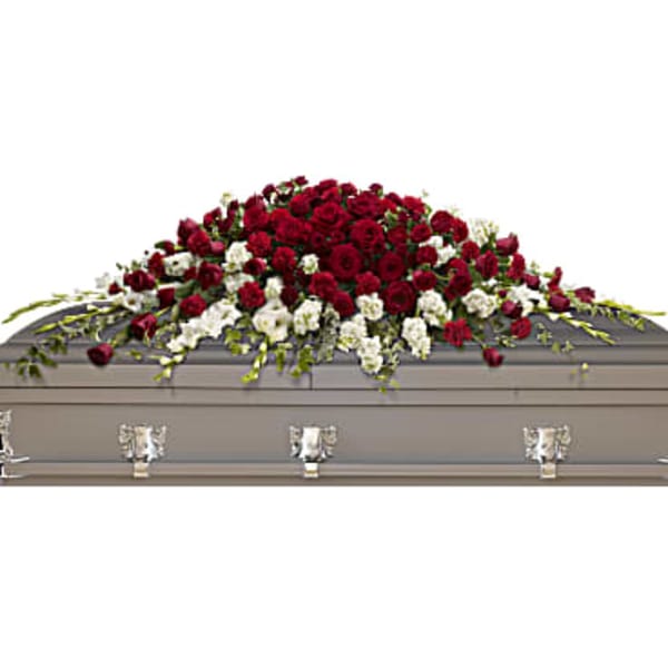 Red and white rose casket spray on a gray coffin