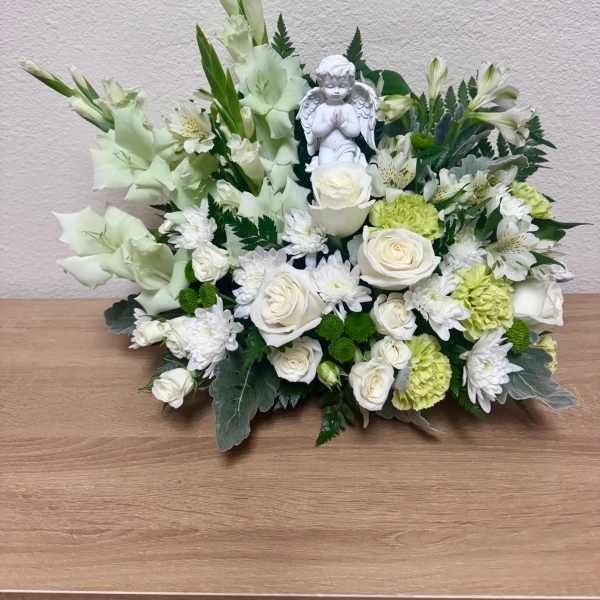 White floral arrangement with roses, chrysanthemums, and an angel figurine
