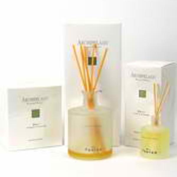 Three boxed reed diffusers with a clear amber bottle in the center