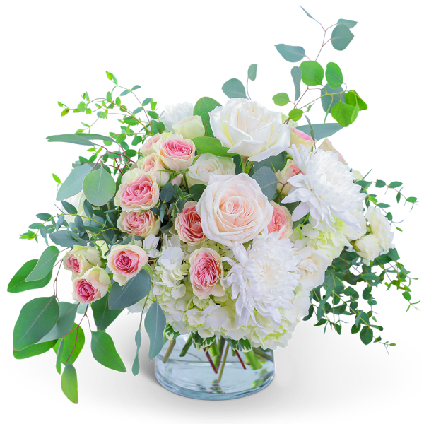 Pink and white roses with white blooms in a clear glass vase