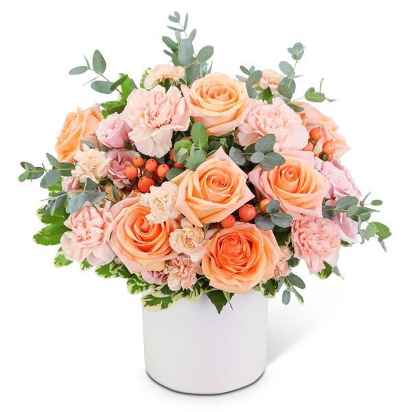 Peach roses and pink carnations in a white vase