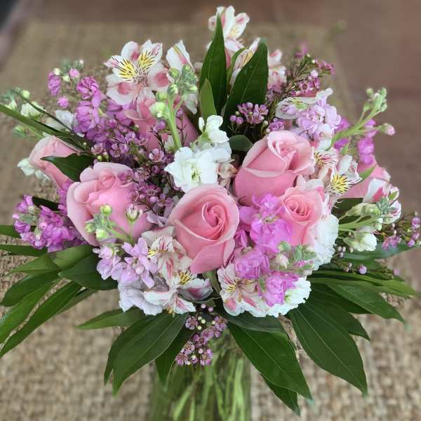 Pink roses and mixed pink-white flowers in a glass vase