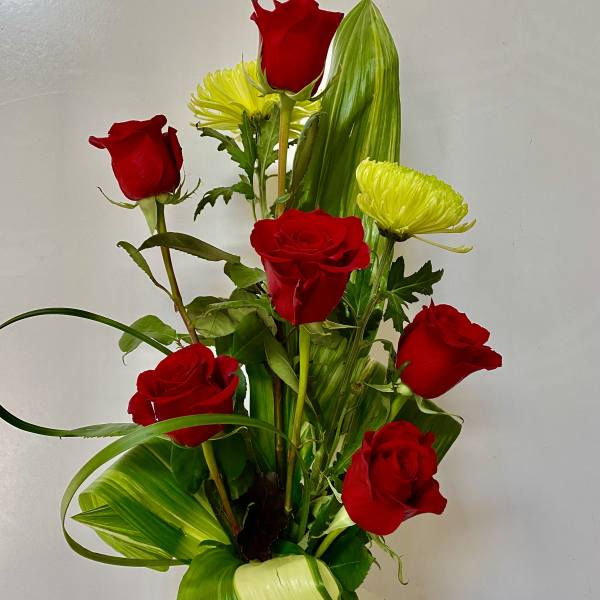 Red roses and yellow chrysanthemums in a glass vase