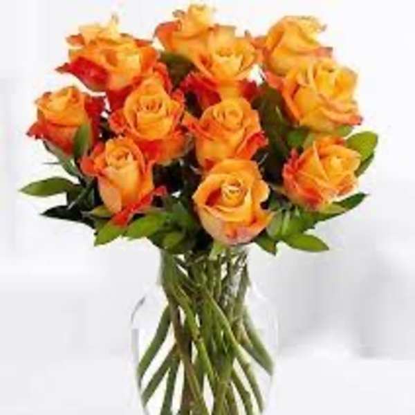 Bouquet of orange and yellow roses in a clear glass vase