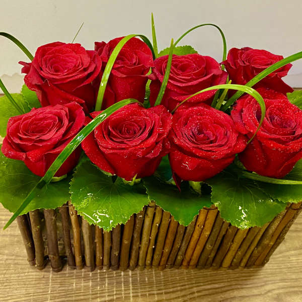 Red roses arranged in a rectangular wooden basket