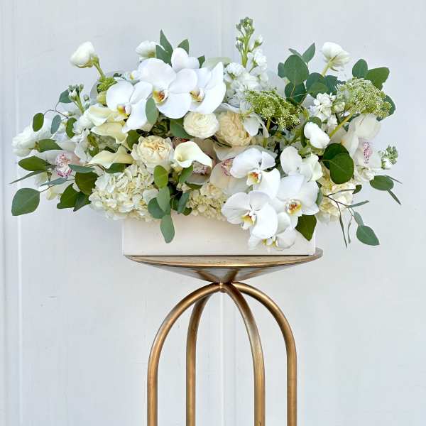 White orchid and rose arrangement in a rectangular vase