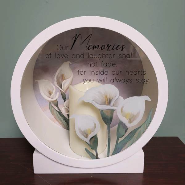 Round memorial plaque with white calla lilies and a sympathy quote