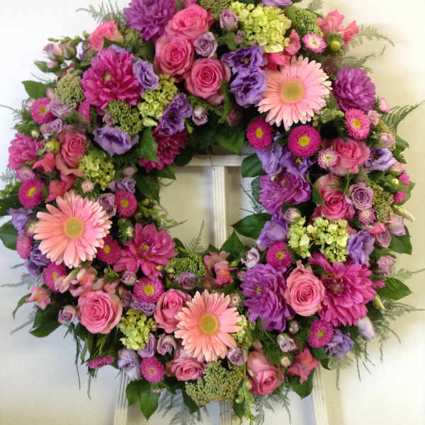 Large pink and purple floral wreath with gerbera daisies and roses