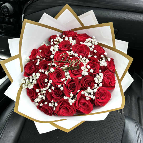 Bouquet of red roses with white baby's breath and a birthday topper