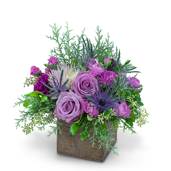 Purple roses and mixed blooms in a wooden box