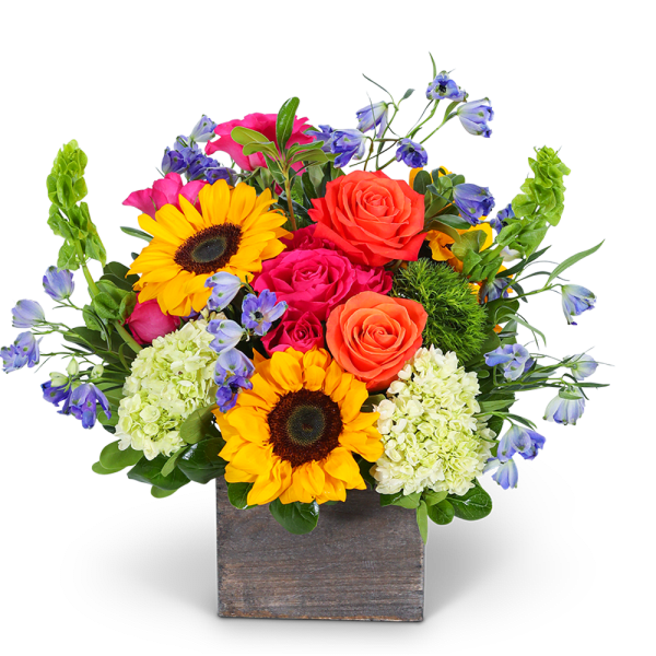 Bright mixed bouquet in a square wooden vase with sunflowers and roses