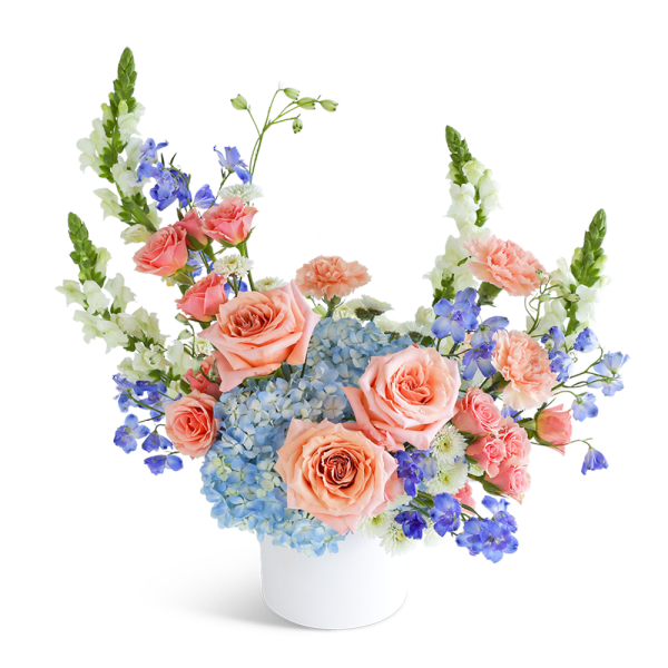 Peach roses and blue hydrangeas in a white vase
