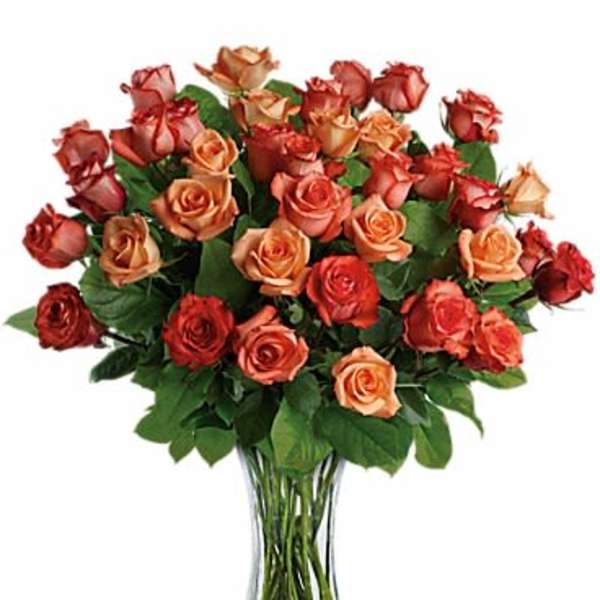 Bouquet of orange and red roses in a clear glass vase