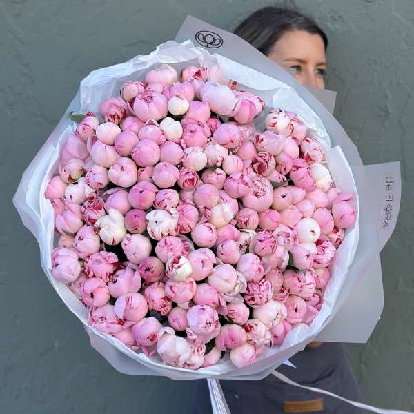 Large bouquet of pink peonies wrapped in white paper