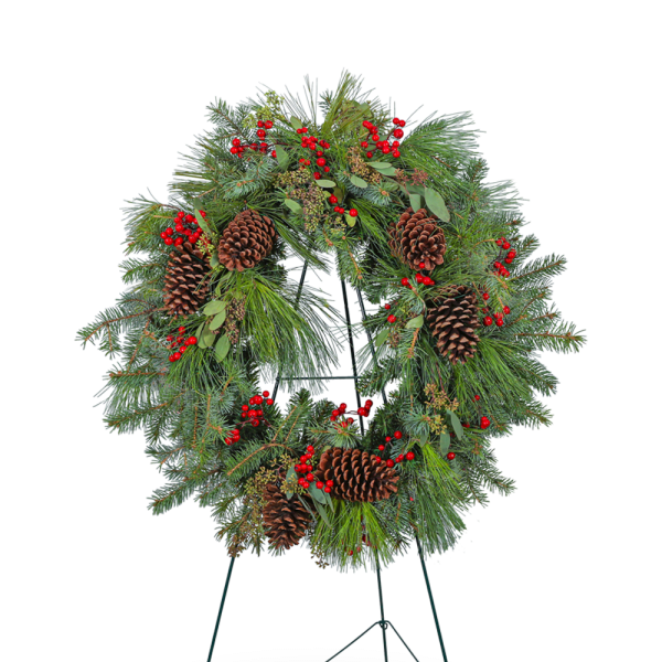 Evergreen wreath with pinecones and red berries on a stand