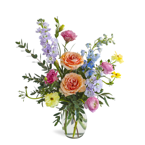 Mixed bouquet with peach roses and pastel flowers in a clear glass vase
