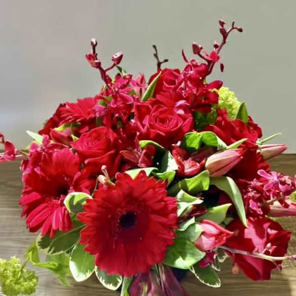 Red bouquet with roses, gerbera daisies, and orchids