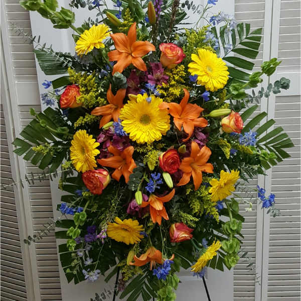 Large standing floral spray with orange lilies and yellow daisies
