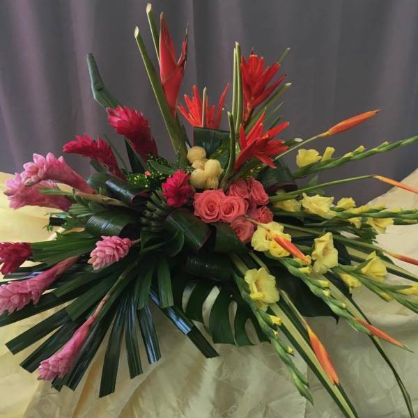 Tropical floral arrangement with pink, red, and yellow blooms