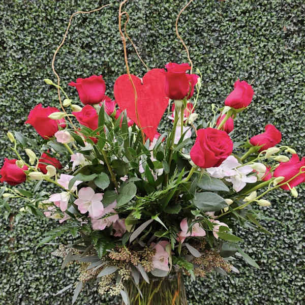Pink roses and a red heart in a glass vase