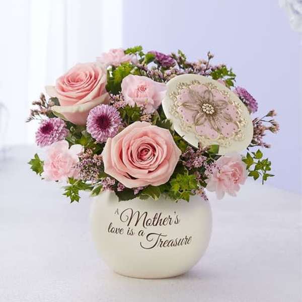 Pink rose bouquet in a cream vase with a decorative plaque