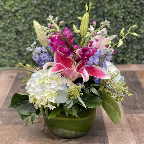 Pink lilies and hydrangeas in a green vase
