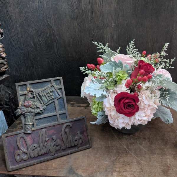 Arrangement of pink hydrangeas and red roses in a low vase