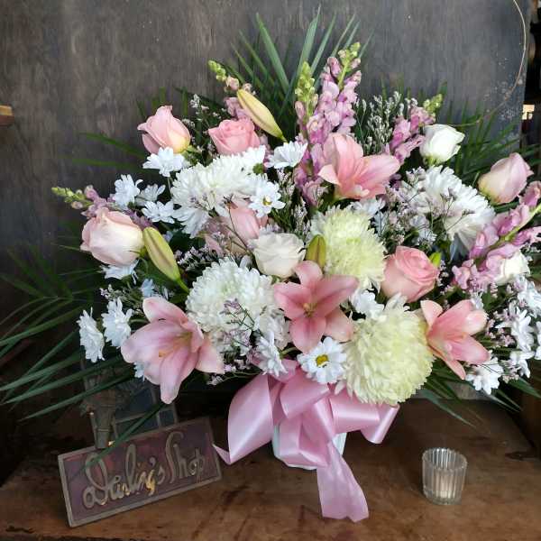 Pink and white mixed flower arrangement with a pink ribbon