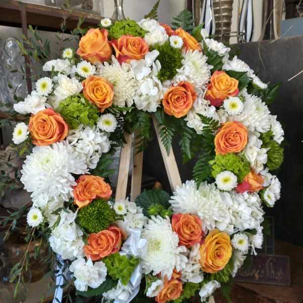 Heart-shaped floral wreath with orange roses and white chrysanthemums