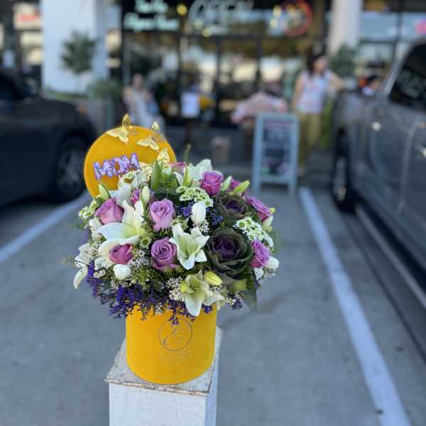 Bouquet of pink and white flowers in a yellow hatbox with a MOM topper