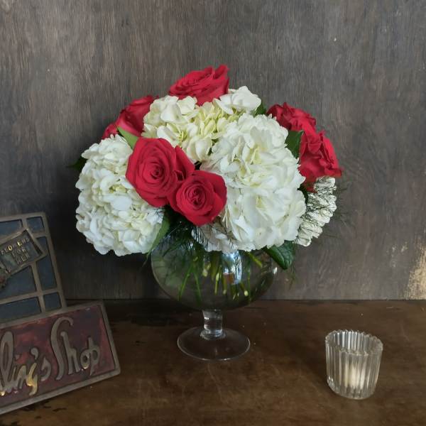 Bouquet of red roses and white hydrangeas in a glass vase