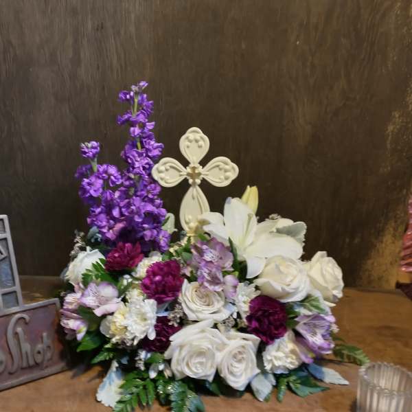 White roses and lilies with purple flowers in a low arrangement