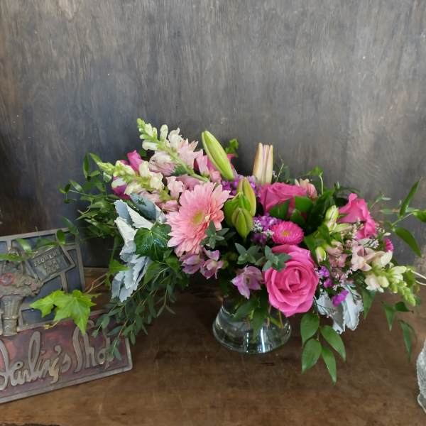 Pink and white mixed flower arrangement in a clear glass vase