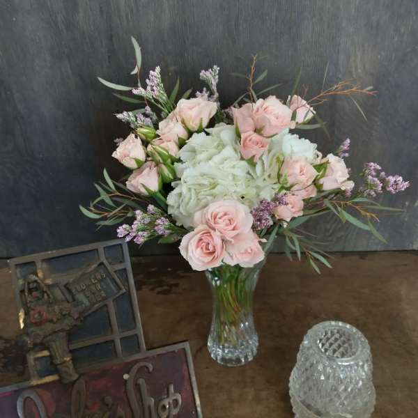 Pink roses and white hydrangeas in a clear glass vase