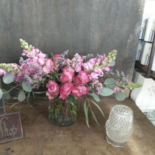 Pink rose and lavender flower arrangement in a glass vase