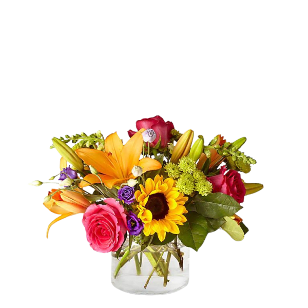 Short glass vase of bright orange lilies, pink roses, a sunflower, and mixed colorful blooms.