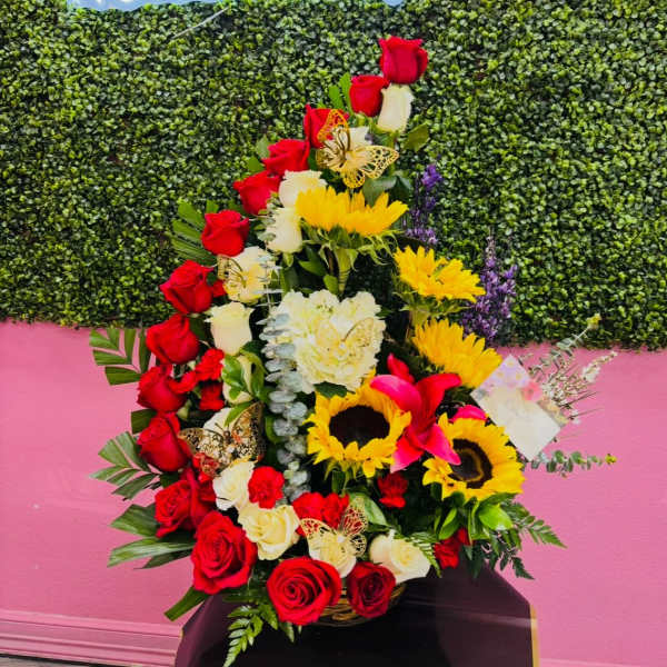 Tall floral arrangement with red and white roses, sunflowers, and pink lilies