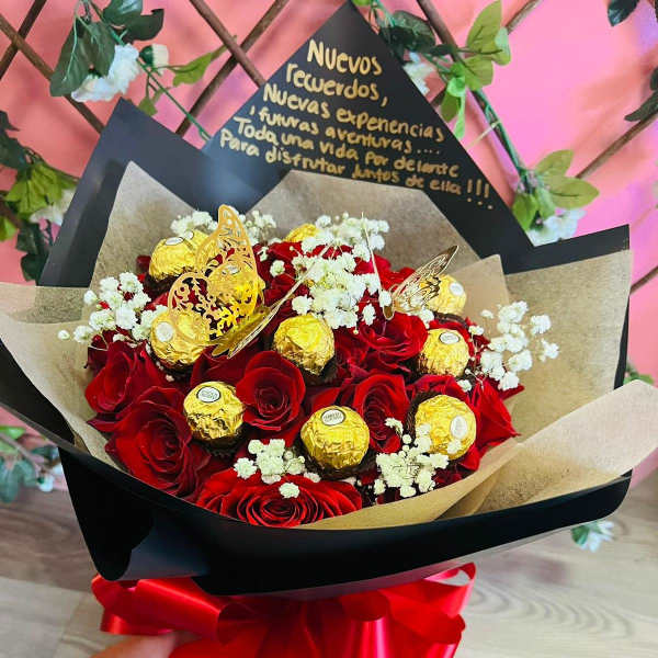 Bouquet of red roses with gold-wrapped chocolates and white baby's breath
