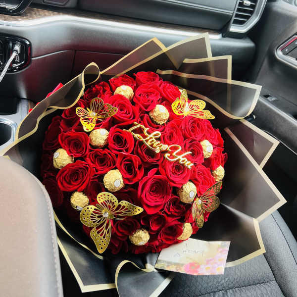 Red rose bouquet with gold-wrapped chocolates and butterfly decorations