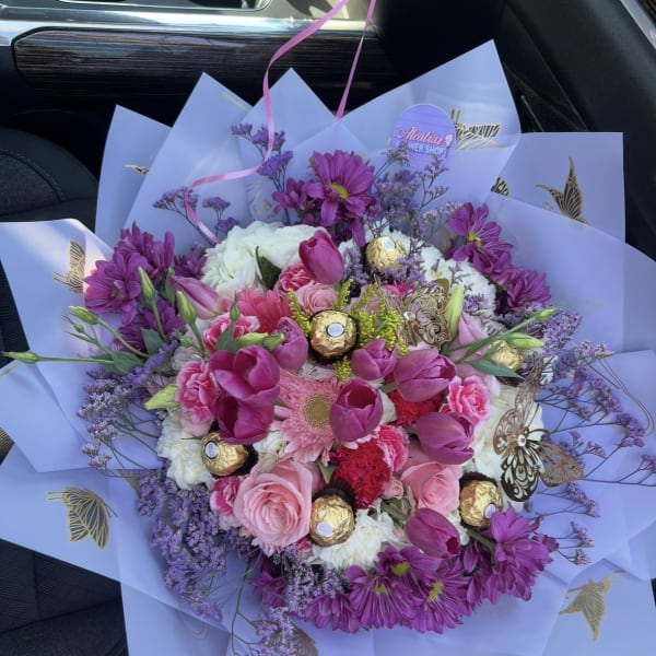 Bouquet of pink and purple flowers with gold-wrapped chocolates