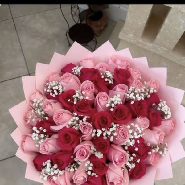 Bouquet of pink and red roses with baby's breath in pink wrap