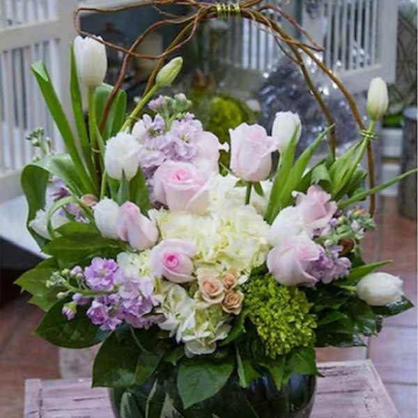 Pink and white tulips with roses in a glass vase