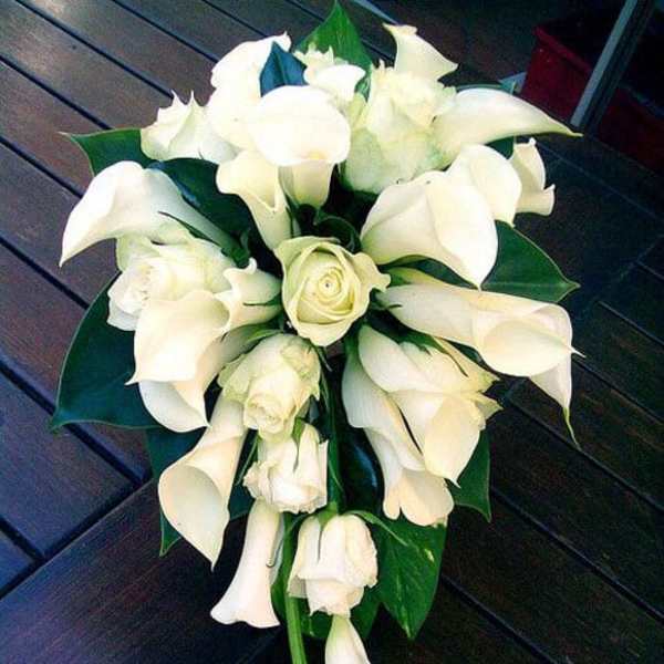 White calla lily and rose bridal bouquet with dark green leaves