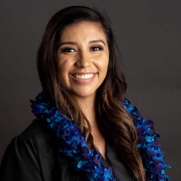 Woman wearing a blue and purple flower lei over a black top