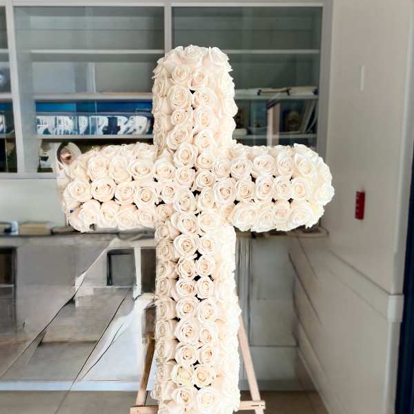 Large white rose cross on a wooden easel