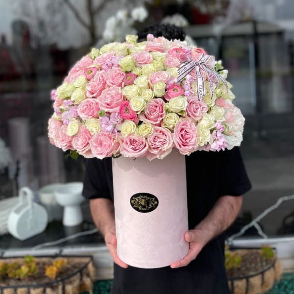 Large pink and cream rose arrangement in a tall round box