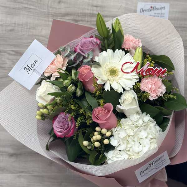 Bouquet of pink and white flowers wrapped in blush paper
