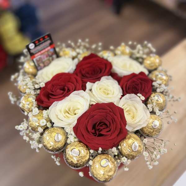 Red and white roses arranged with gold-wrapped chocolates