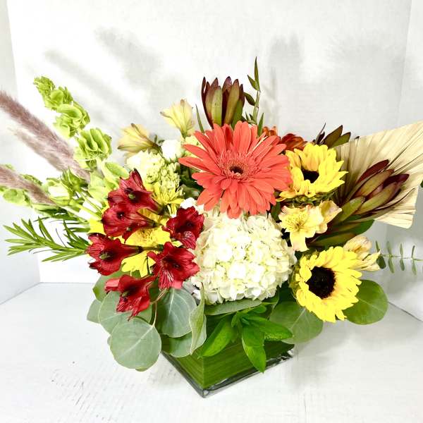 Mixed bouquet with gerbera daisies, hydrangea, and alstroemeria in a glass vase