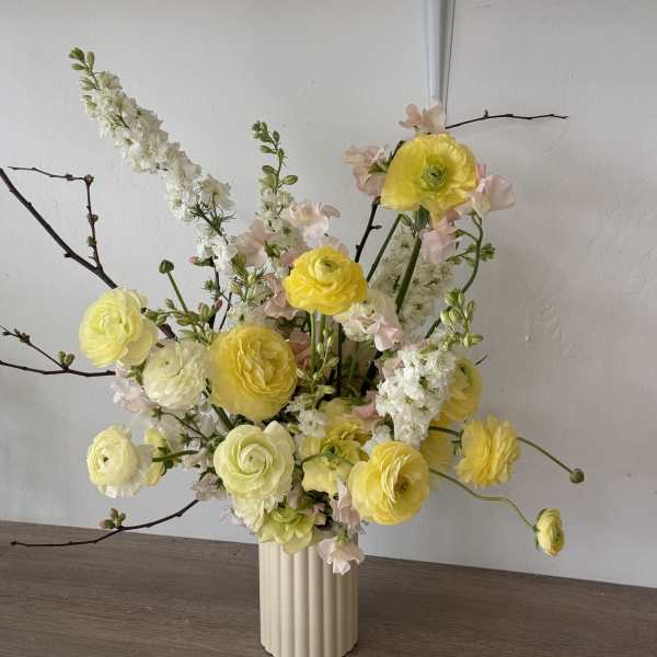 Yellow and white floral arrangement in a ribbed vase